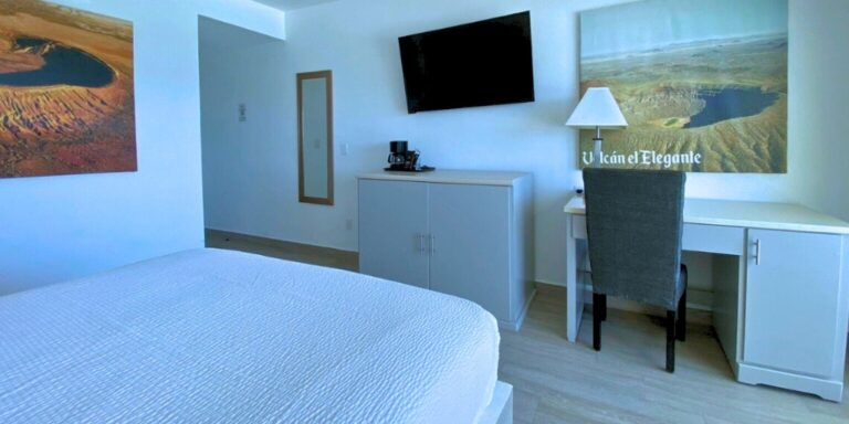 Single room interior with bed and TV at Playa Bonita Resort