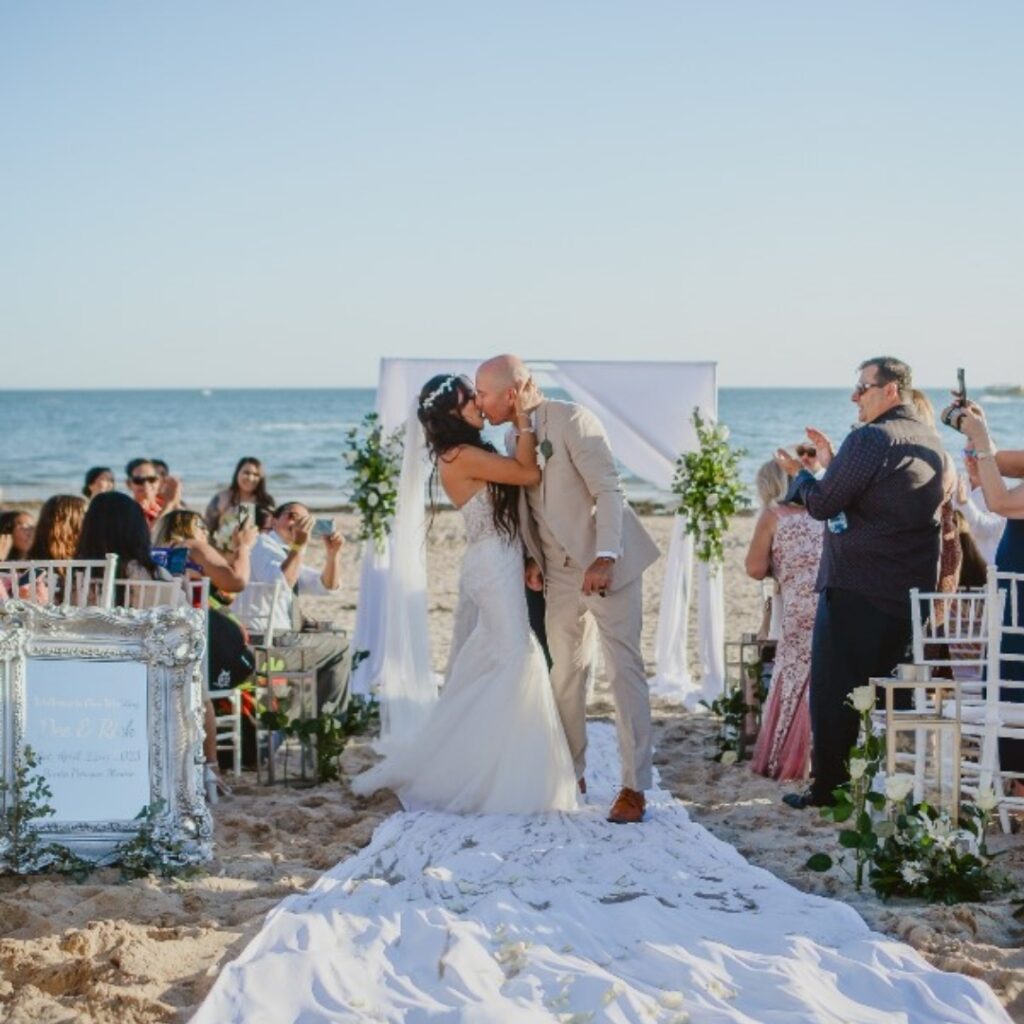 Beach wedding ceremony setup at Puesta del Sol restaurant with the ocean in the background.